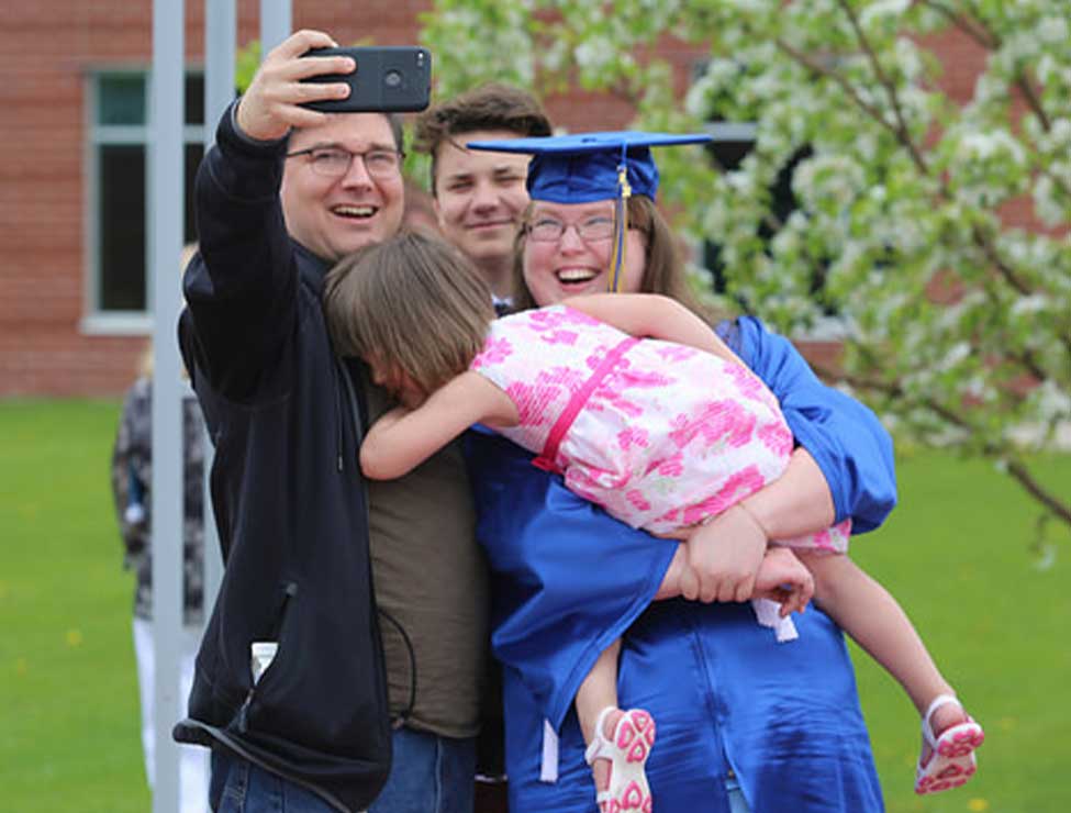 Graduate taking selfie with family