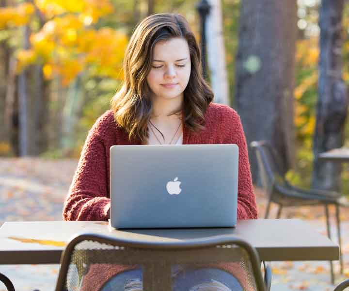 Student working on laptop outside