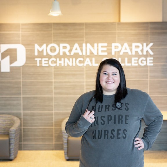 Nursing student smiling in a college hallway