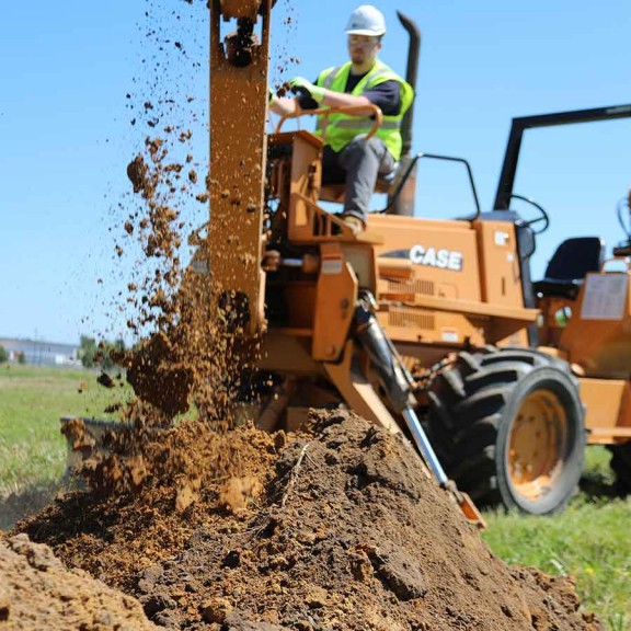 Construction worker on tractor dumping dirt