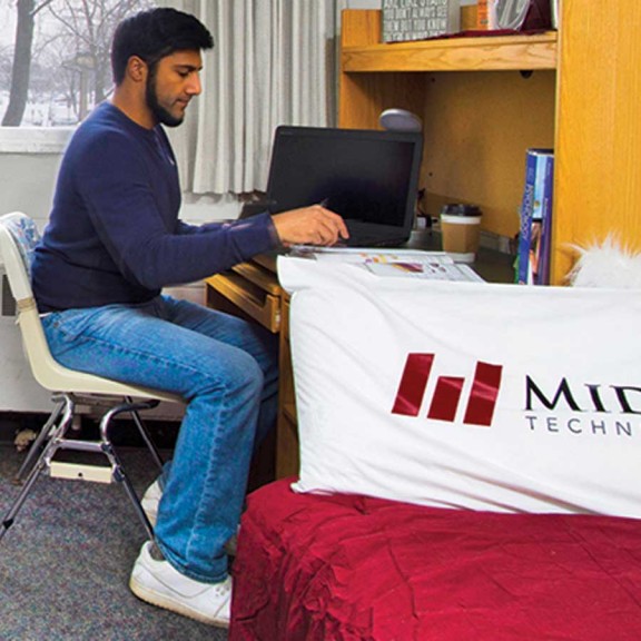 Student studying at a desk in a dorm room
