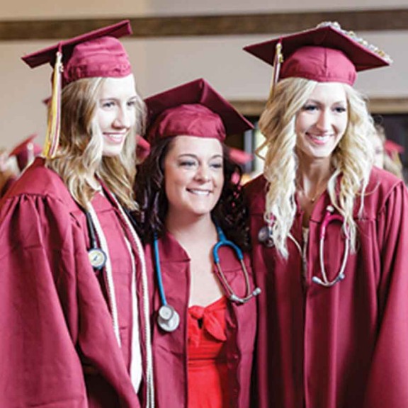 Three graduates with stethoscopes