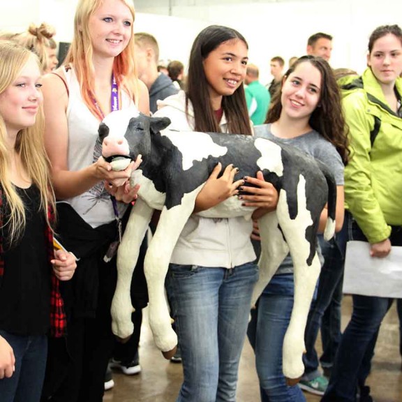 Young students with baby cow prop