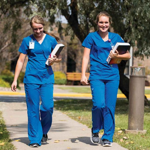 Medical students in scrubs walking on campus